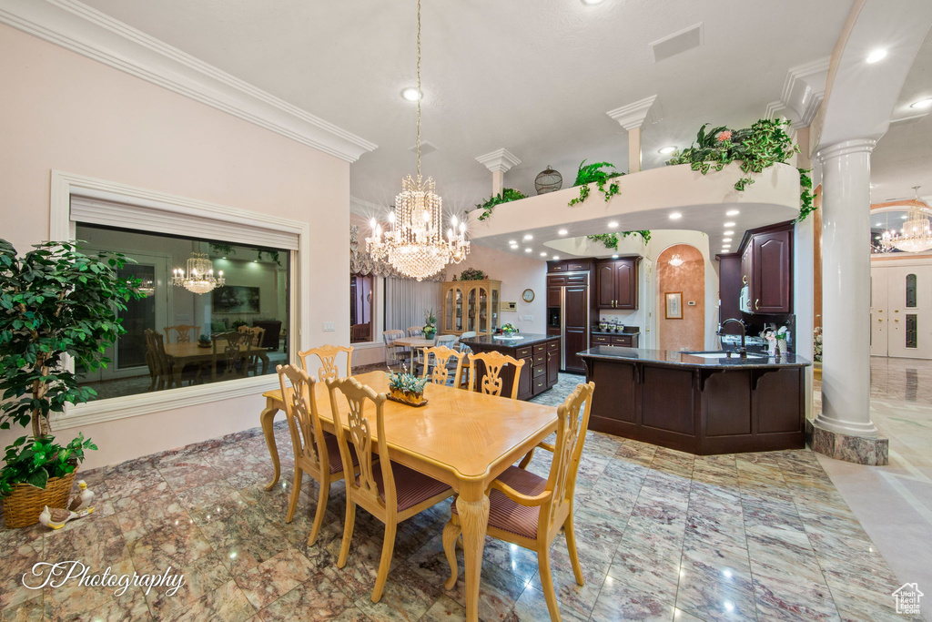 Dining space with ornamental molding, a chandelier, recessed lighting, and ornate columns