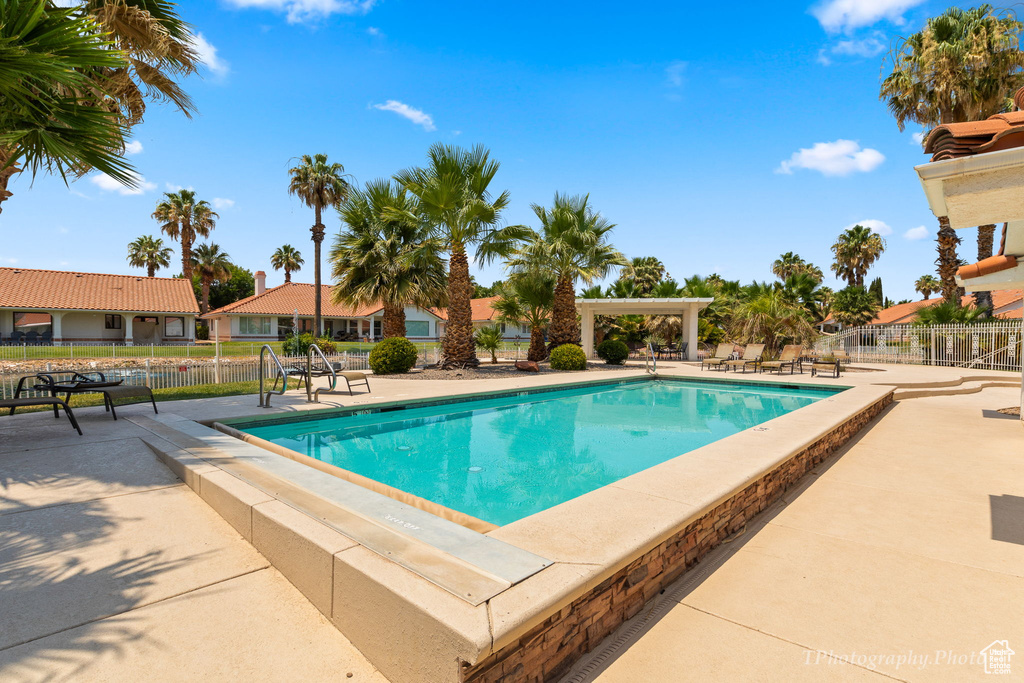 Community pool with a patio and fence