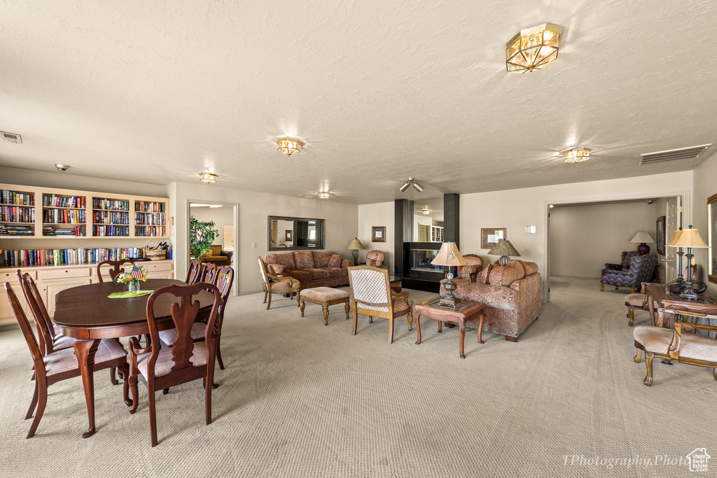 Dining space with carpet floors and a textured ceiling