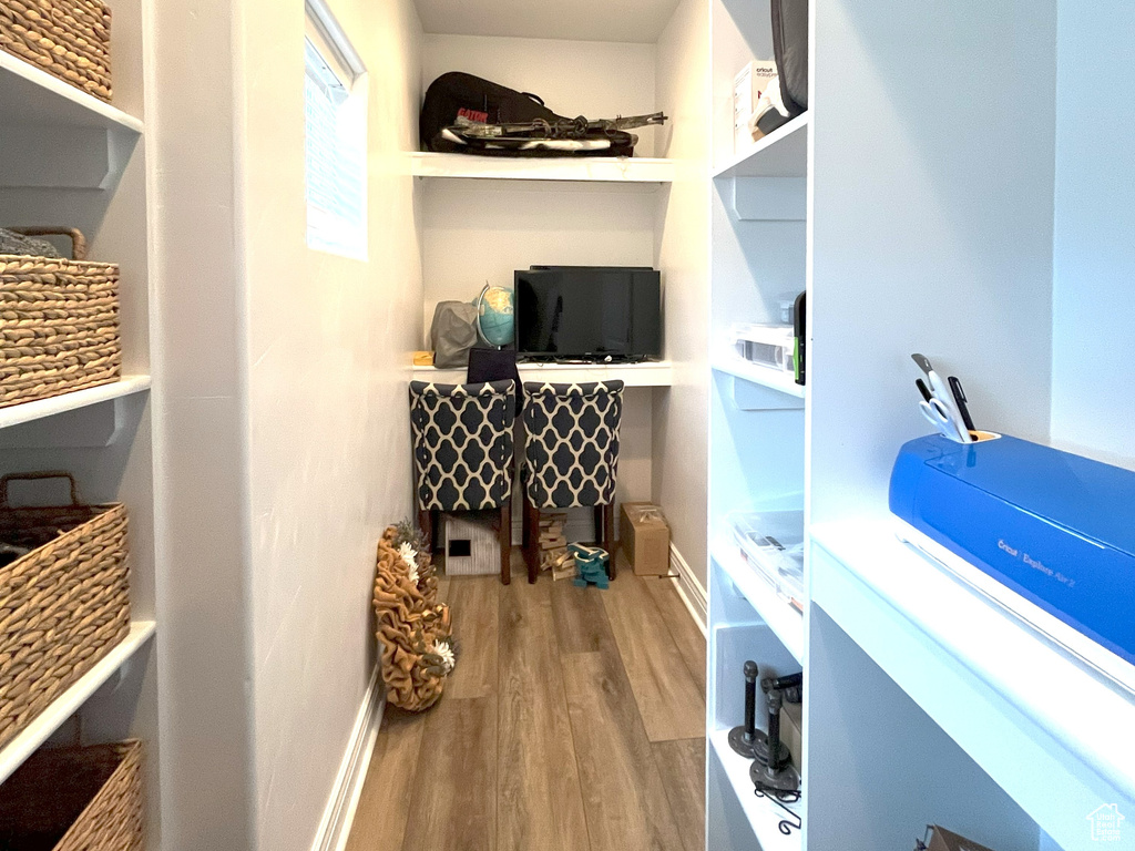 Walk in closet with wood finished floors