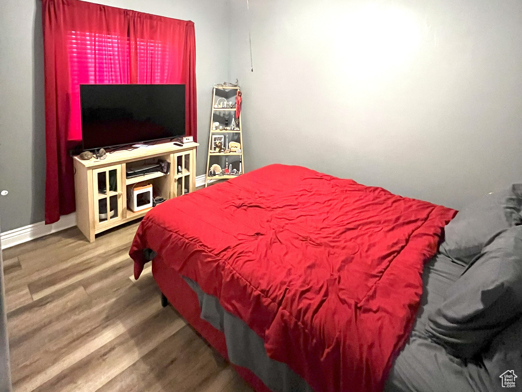Bedroom with a textured ceiling, wood finished floors, a ceiling fan, and baseboards