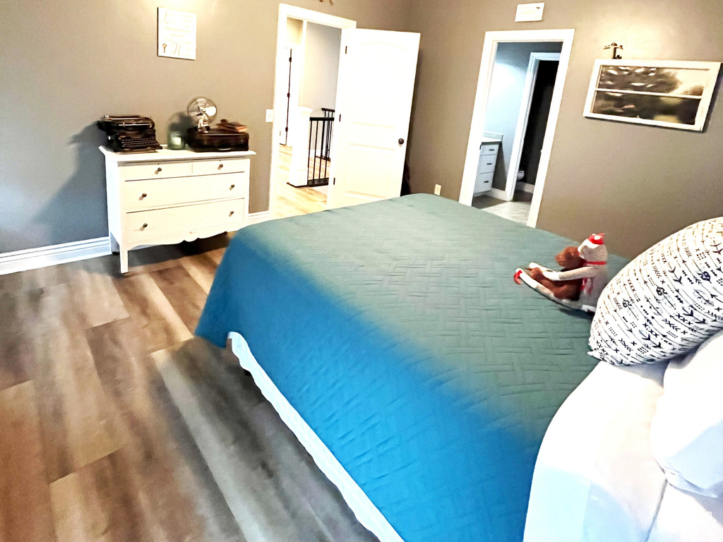 Bedroom featuring wood finished floors, a ceiling fan, baseboards, and a textured ceiling