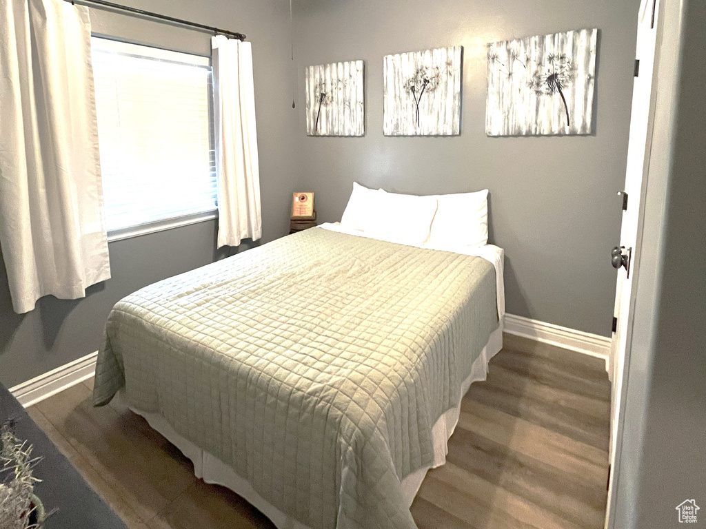 Bedroom featuring baseboards, wood finished floors, a ceiling fan, and a textured ceiling