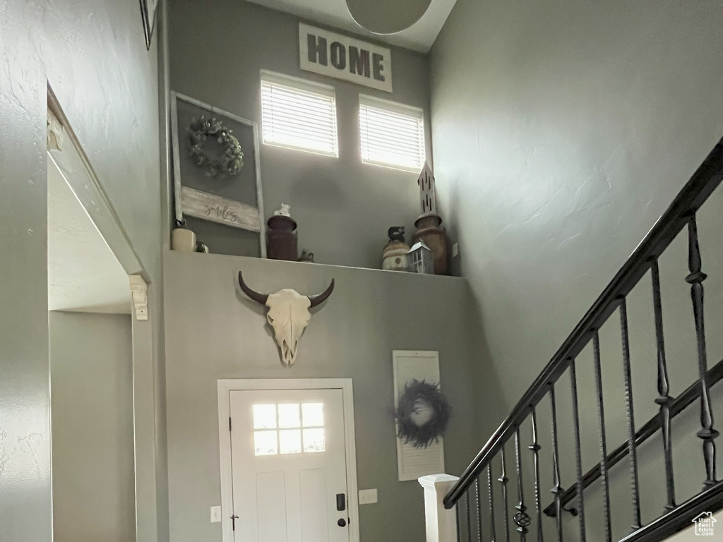 Entrance foyer featuring stairs, a high ceiling, wood finished floors, and baseboards