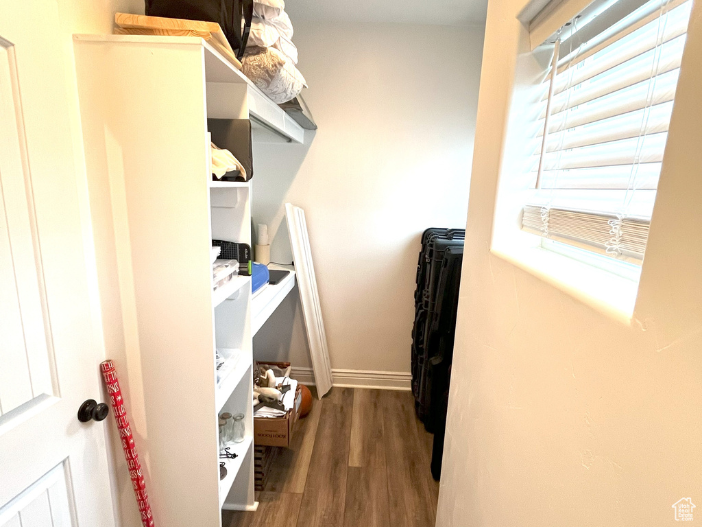 Walk in closet with wood finished floors