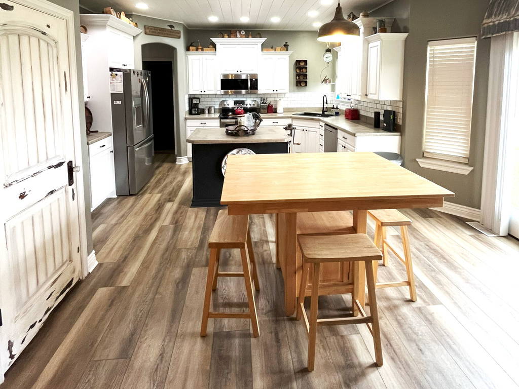 Kitchen featuring stainless steel appliances, light countertops, white cabinets, wood finished floors, and recessed lighting