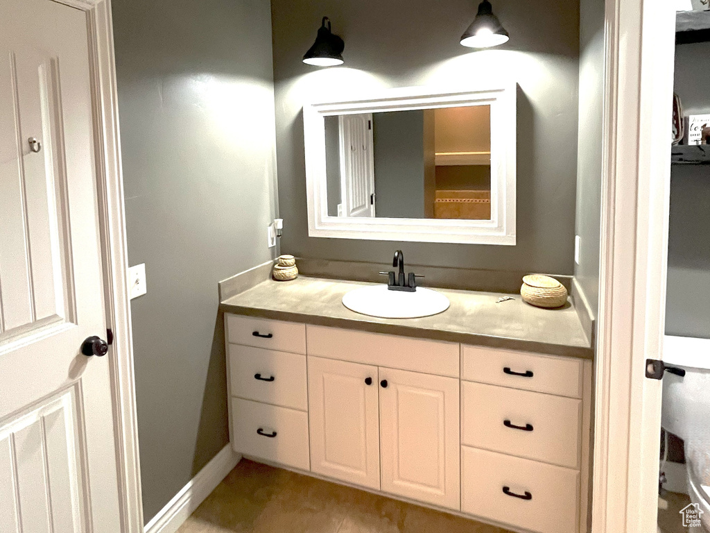 Bathroom featuring vanity, baseboards, and tile patterned flooring