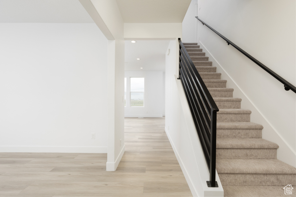 Stairs featuring recessed lighting, wood finished floors, and baseboards