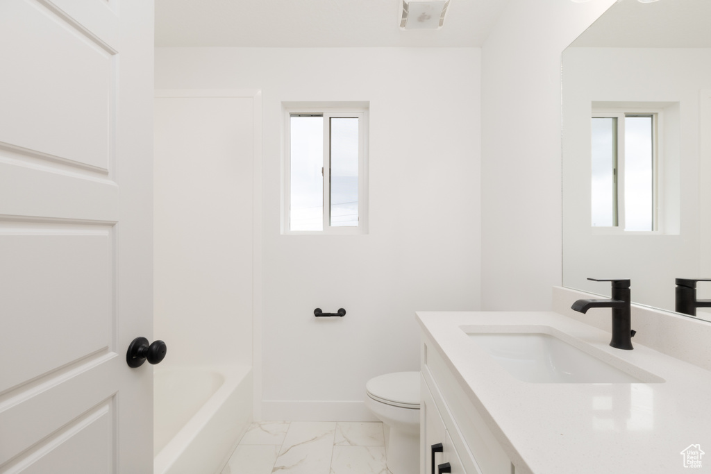 Full bathroom featuring marble finish flooring, vanity, toilet, and baseboards