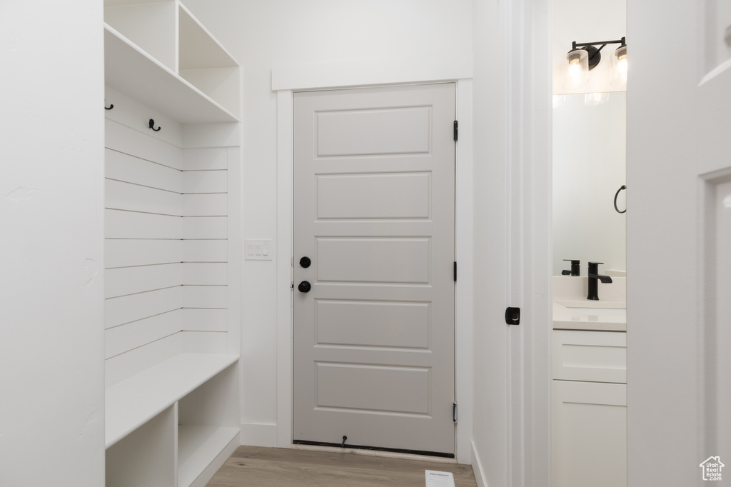Mudroom featuring light wood-style flooring and a sink