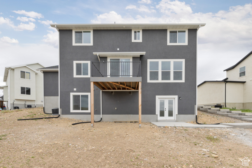 Back of property with french doors and stucco siding