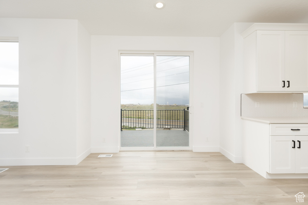 Unfurnished dining area with light wood-style floors, baseboards, plenty of natural light, and recessed lighting