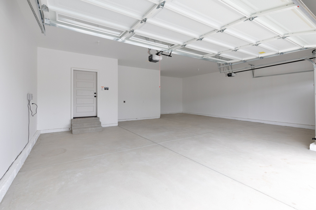 Garage with a garage door opener and baseboards