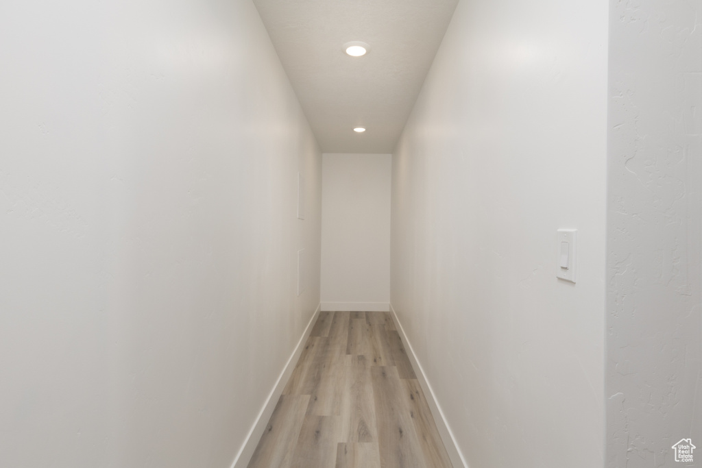 Corridor with light wood-type flooring, recessed lighting, and baseboards
