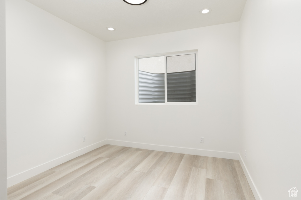 Empty room featuring light wood finished floors, baseboards, and recessed lighting