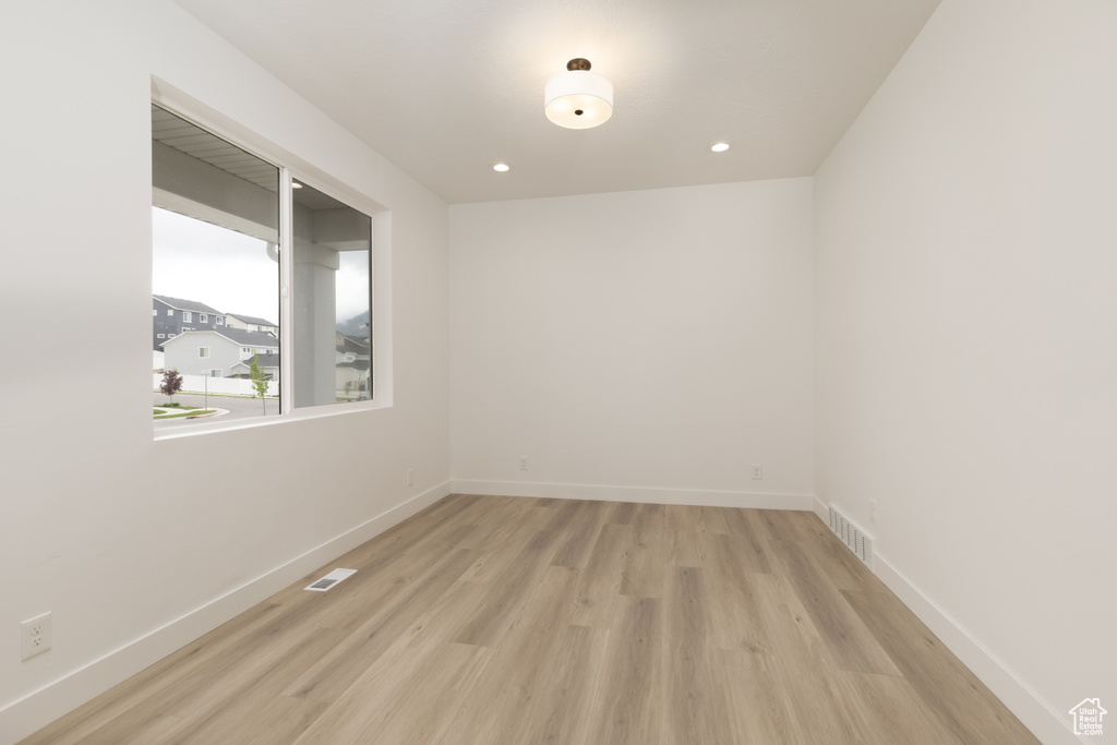 Spare room with light wood-type flooring, baseboards, and recessed lighting