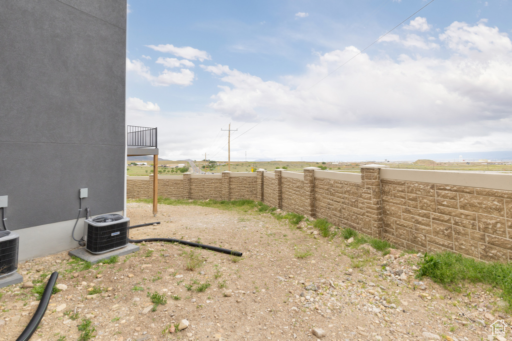 View of yard featuring fence and cooling unit