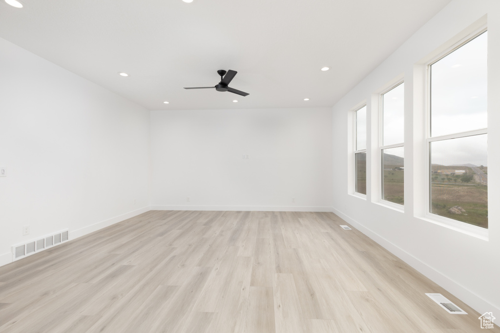 Empty room featuring light wood-style floors, a ceiling fan, recessed lighting, and baseboards