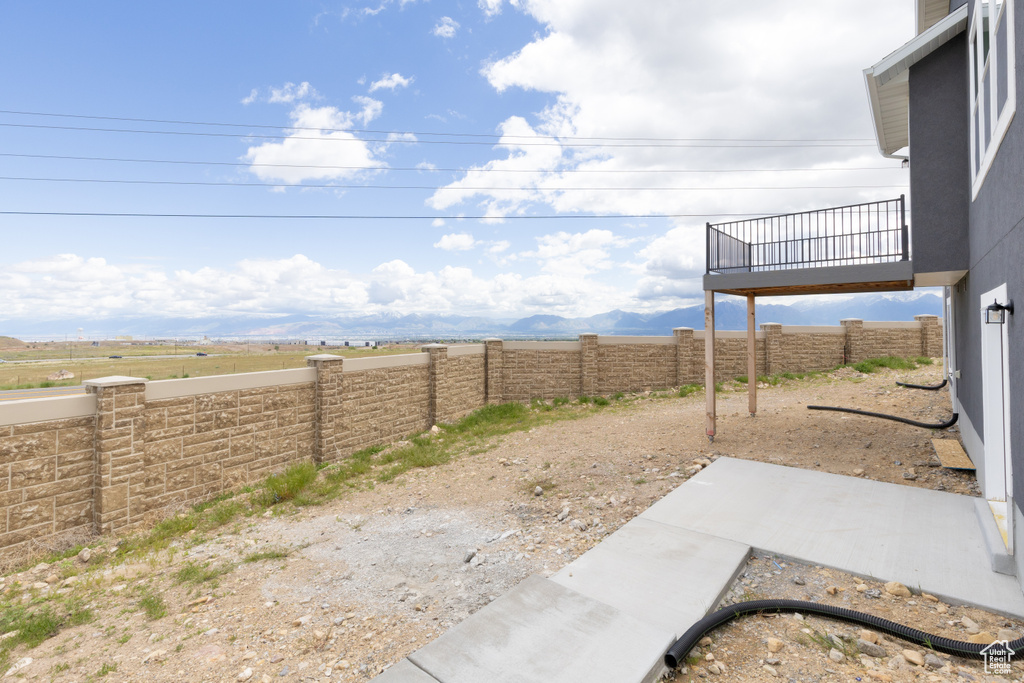 Fenced backyard featuring a balcony