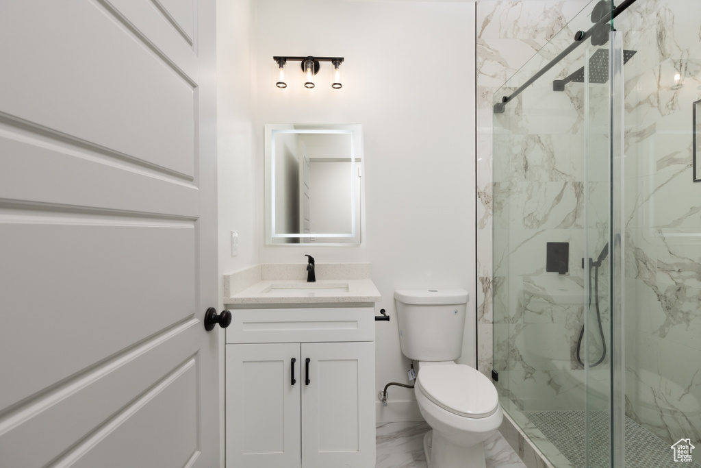 Full bath with marble finish flooring, a marble finish shower, vanity, and toilet