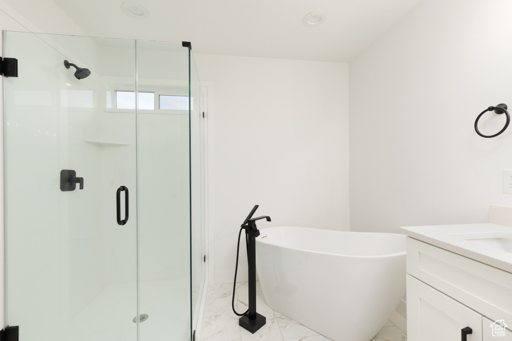 Bathroom with marble finish flooring, a stall shower, and a soaking tub