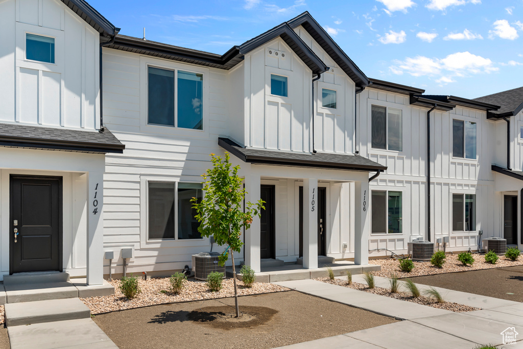 View of front of property featuring board and batten siding, covered porch, and central air condition unit