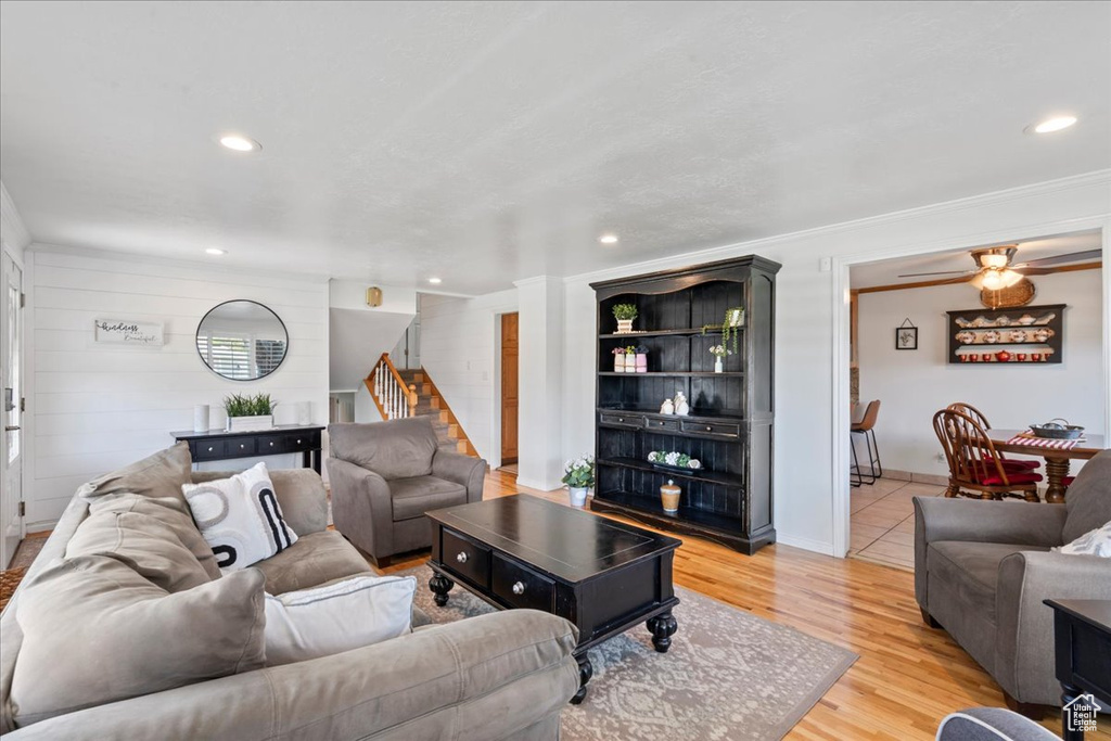 Living area with light wood-type flooring, stairs, recessed lighting, a ceiling fan, and crown molding
