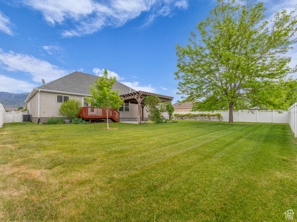 View of yard featuring a wooden deck and central AC