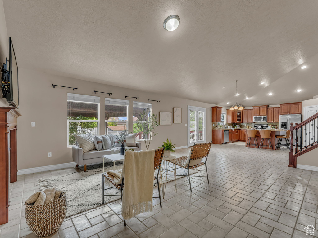 Living room with recessed lighting, baseboards, a textured ceiling, and stairway