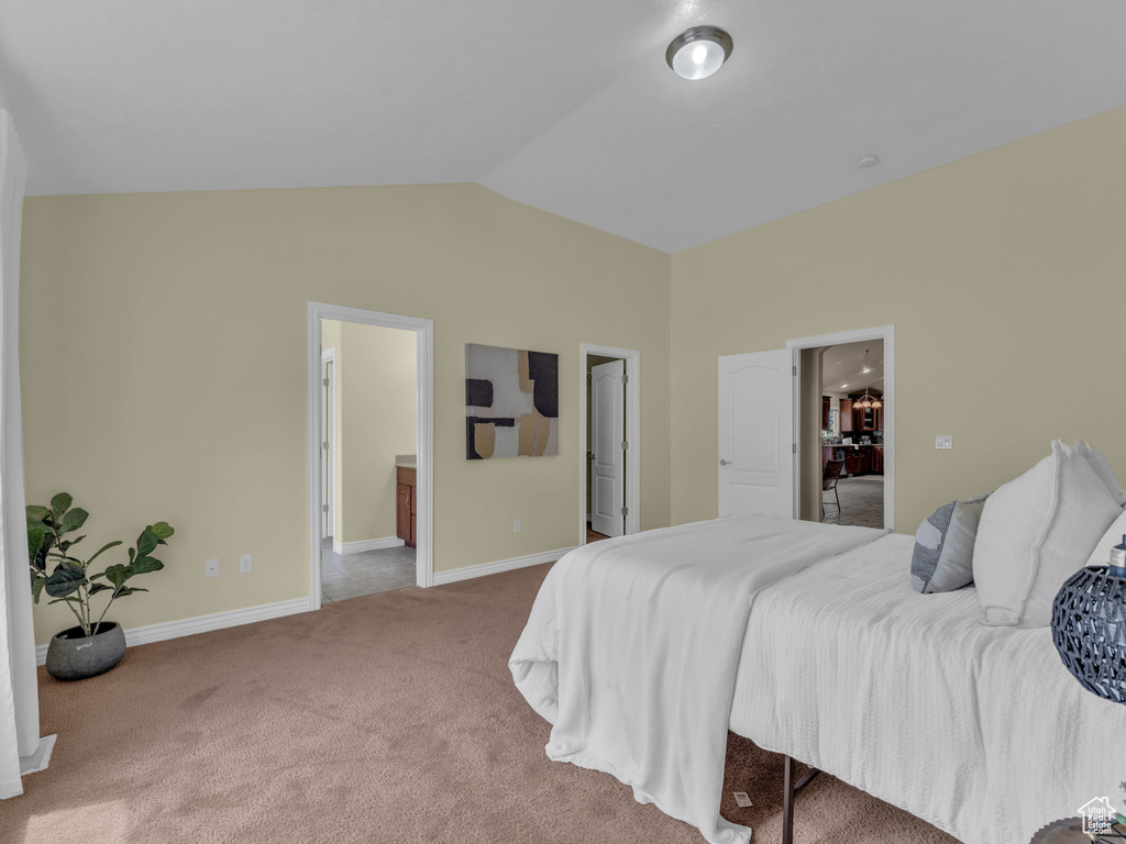 Bedroom with carpet floors, vaulted ceiling, and baseboards