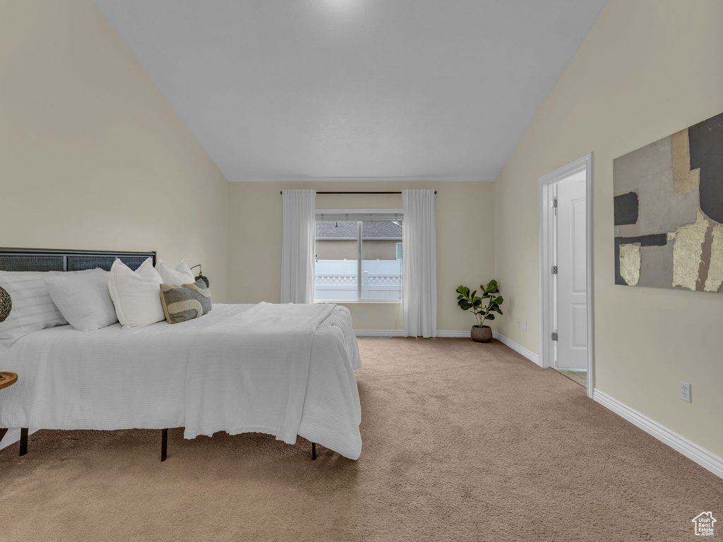 Bedroom with carpet floors, vaulted ceiling, and baseboards