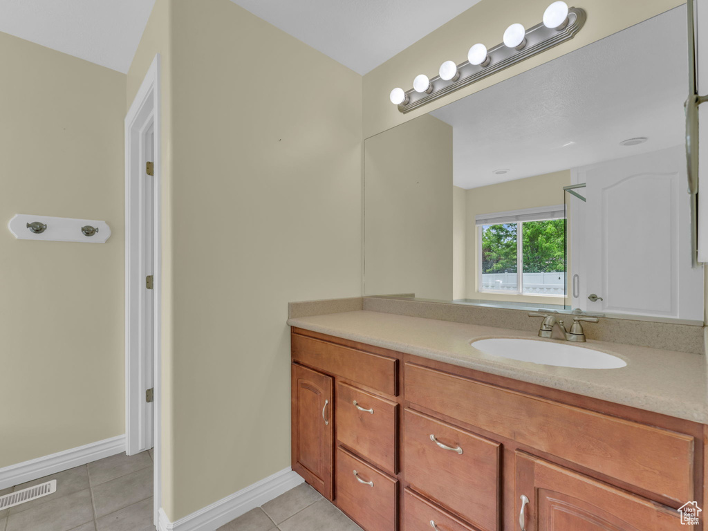 Bathroom featuring tile patterned flooring, vanity, and baseboards