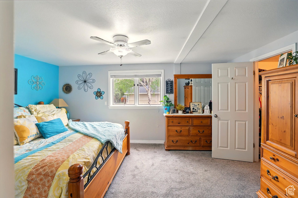 Bedroom featuring light colored carpet, baseboards, and a ceiling fan