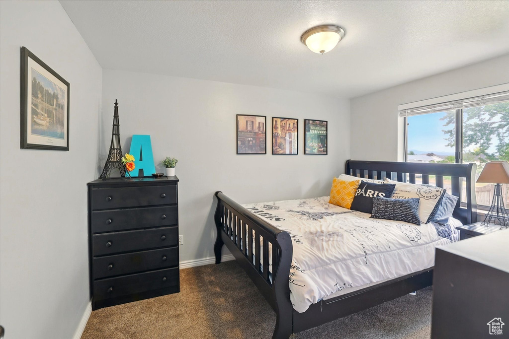 Bedroom with carpet flooring, baseboards, and access to outside