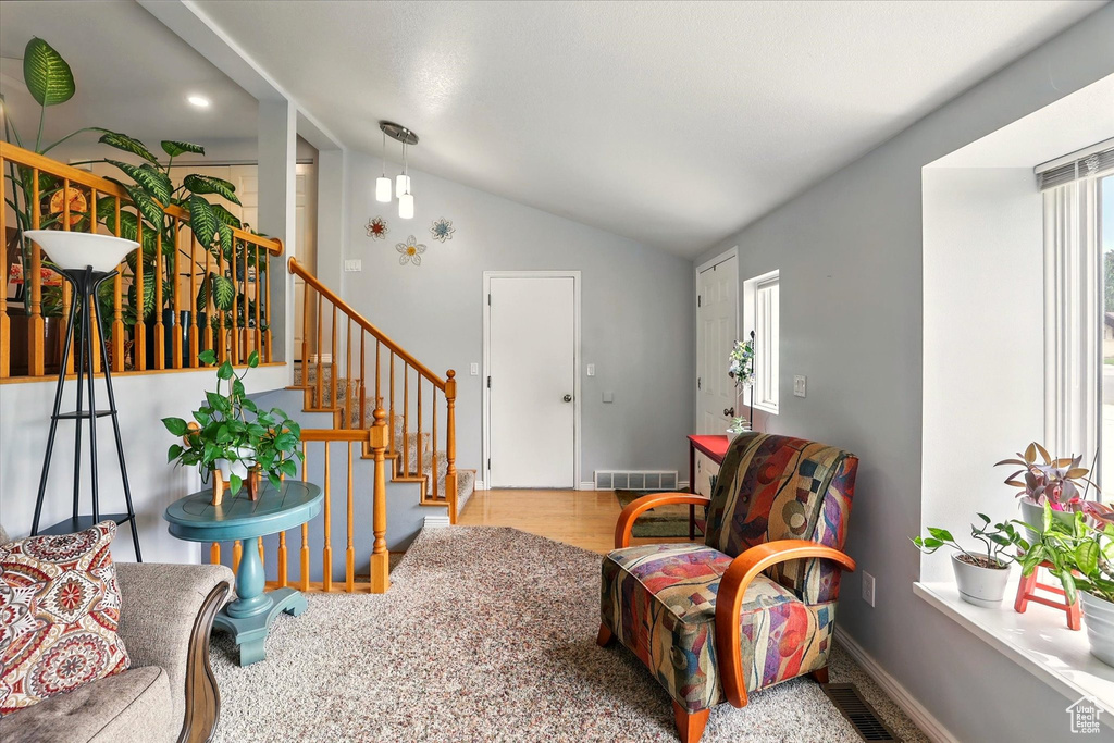 Foyer featuring vaulted ceiling, stairway, wood finished floors, and baseboards
