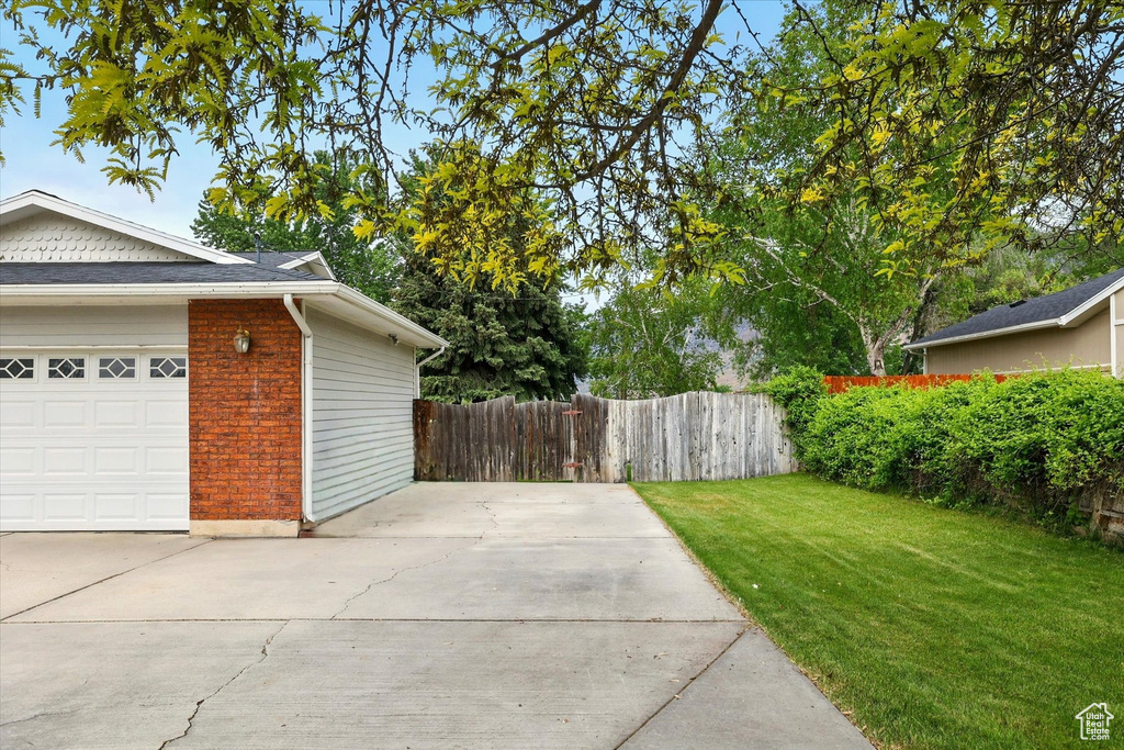 View of yard featuring concrete driveway and a garage
