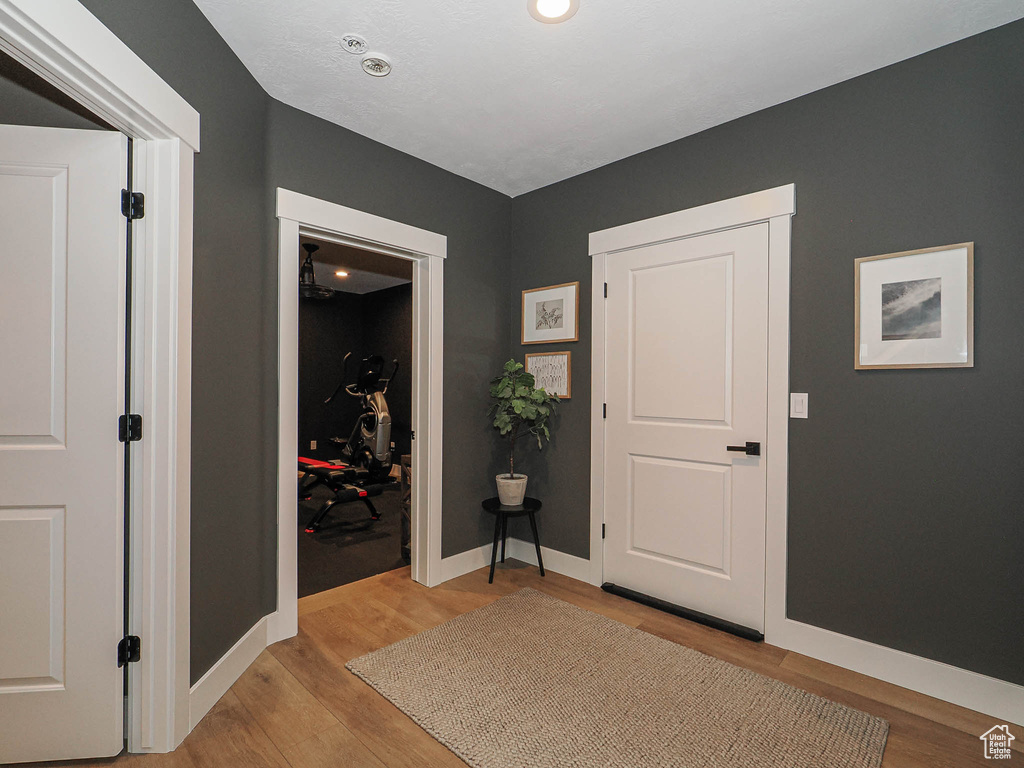 Foyer with light wood-style flooring and baseboards