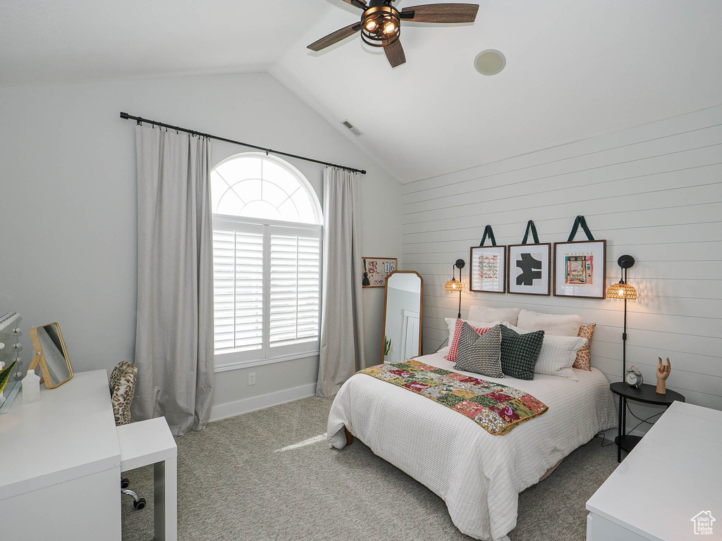 Carpeted bedroom with vaulted ceiling, a ceiling fan, and baseboards