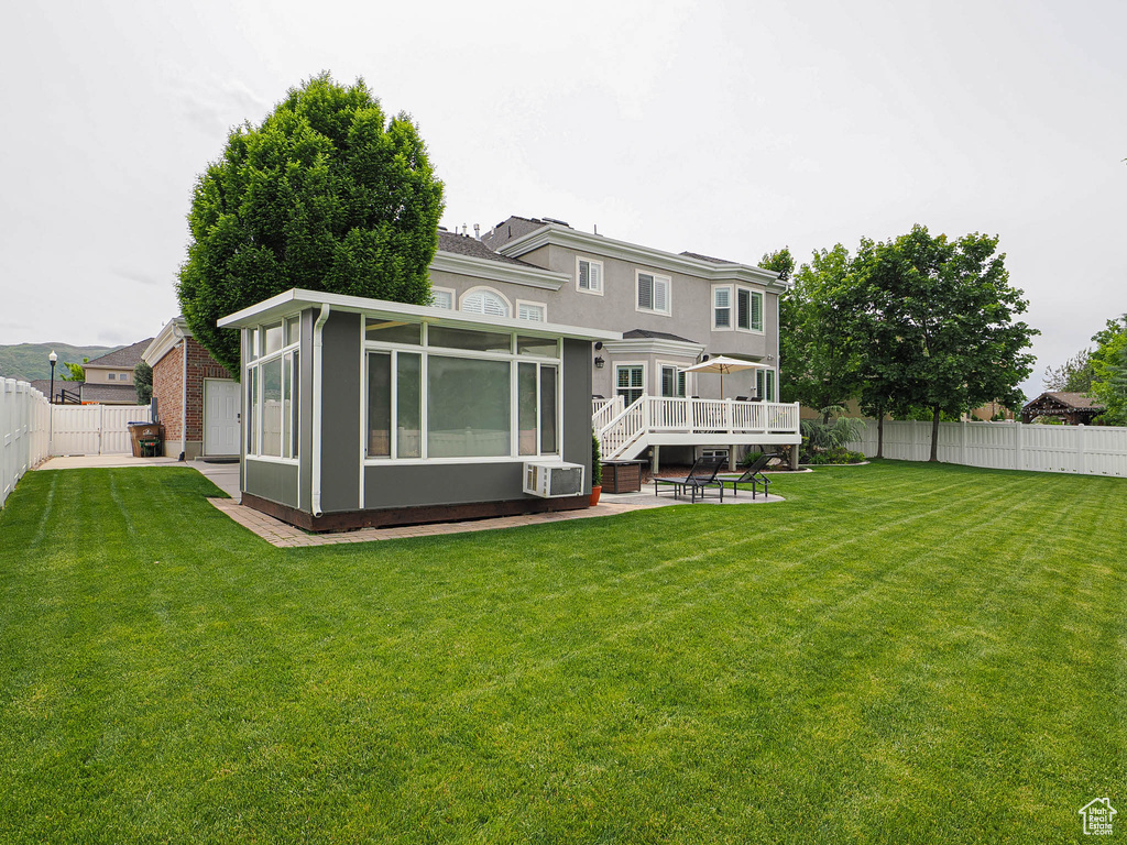 Back of house with a sunroom, a patio, and cooling unit
