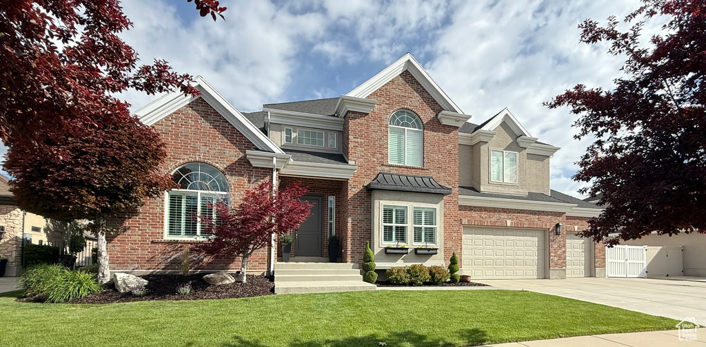 View of front facade with concrete driveway, an attached garage, and brick siding