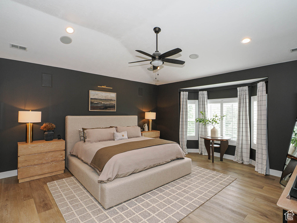 Bedroom featuring baseboards, vaulted ceiling, wood finished floors, ceiling fan, and recessed lighting