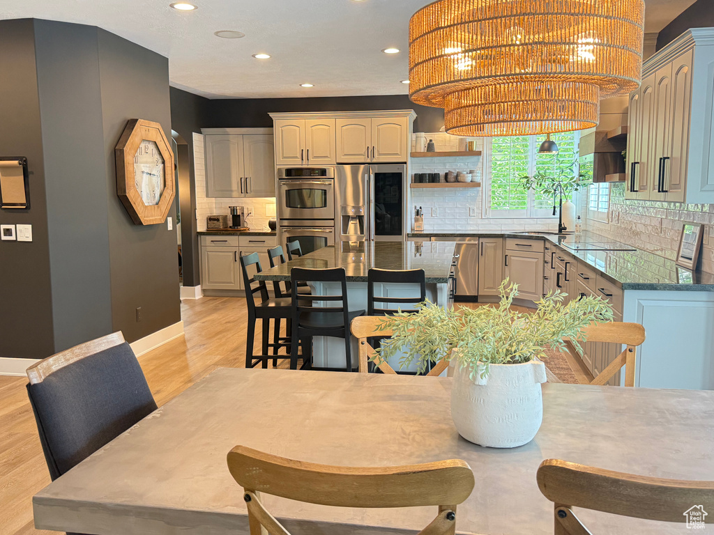 Dining room with recessed lighting, light wood-style flooring, and baseboards