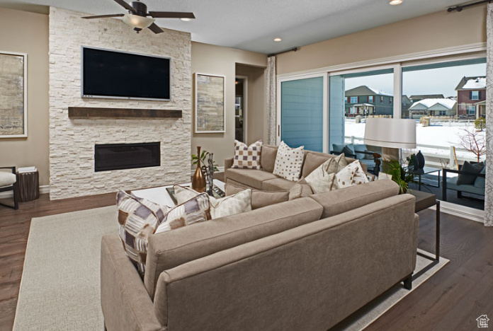 Living area featuring a ceiling fan, a fireplace, dark wood-type flooring, recessed lighting, and baseboards