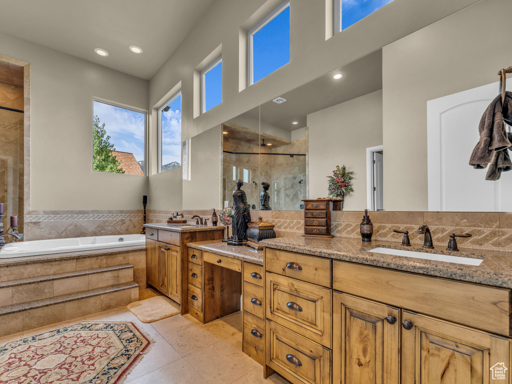 Full bath with a stall shower, vanity, a garden tub, a towering ceiling, and recessed lighting