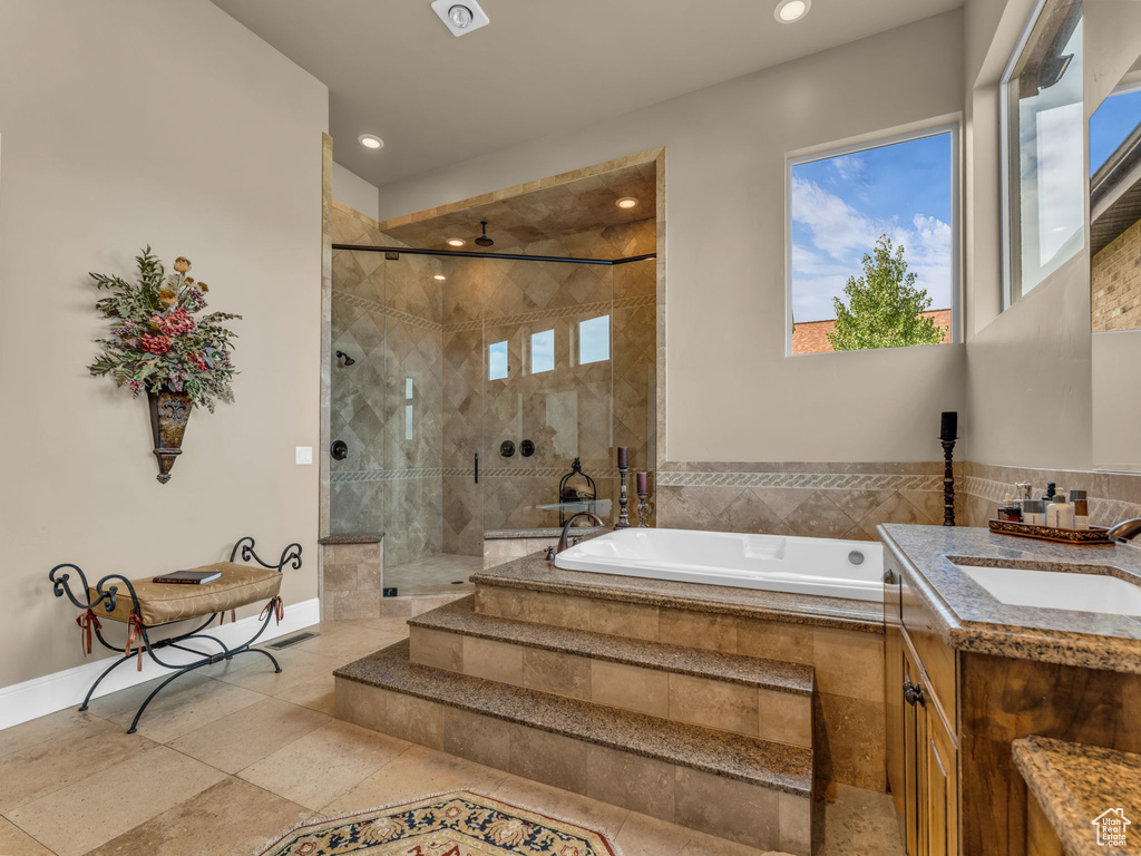 Bathroom with a shower stall, a bath, vanity, recessed lighting, and baseboards