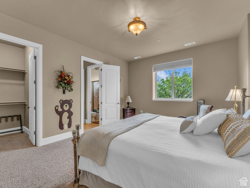Bedroom featuring carpet, baseboards, and a walk in closet