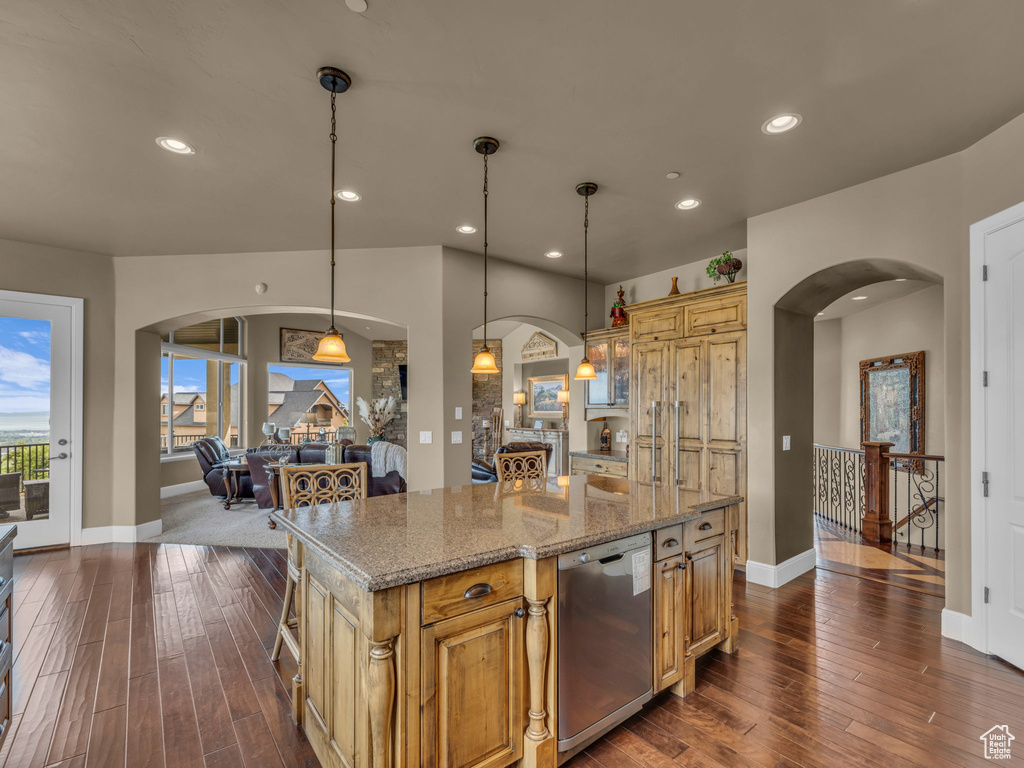 Kitchen with arched walkways, stainless steel dishwasher, dark wood finished floors, and recessed lighting