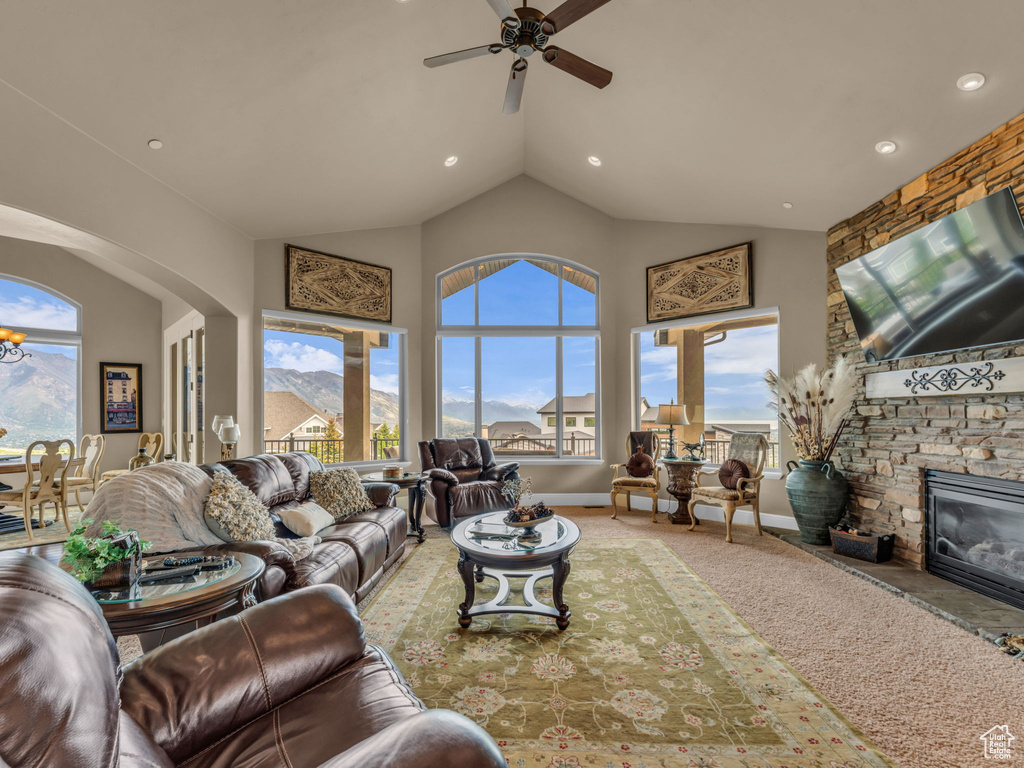 Living room with plenty of natural light, a ceiling fan, high vaulted ceiling, recessed lighting, and a fireplace