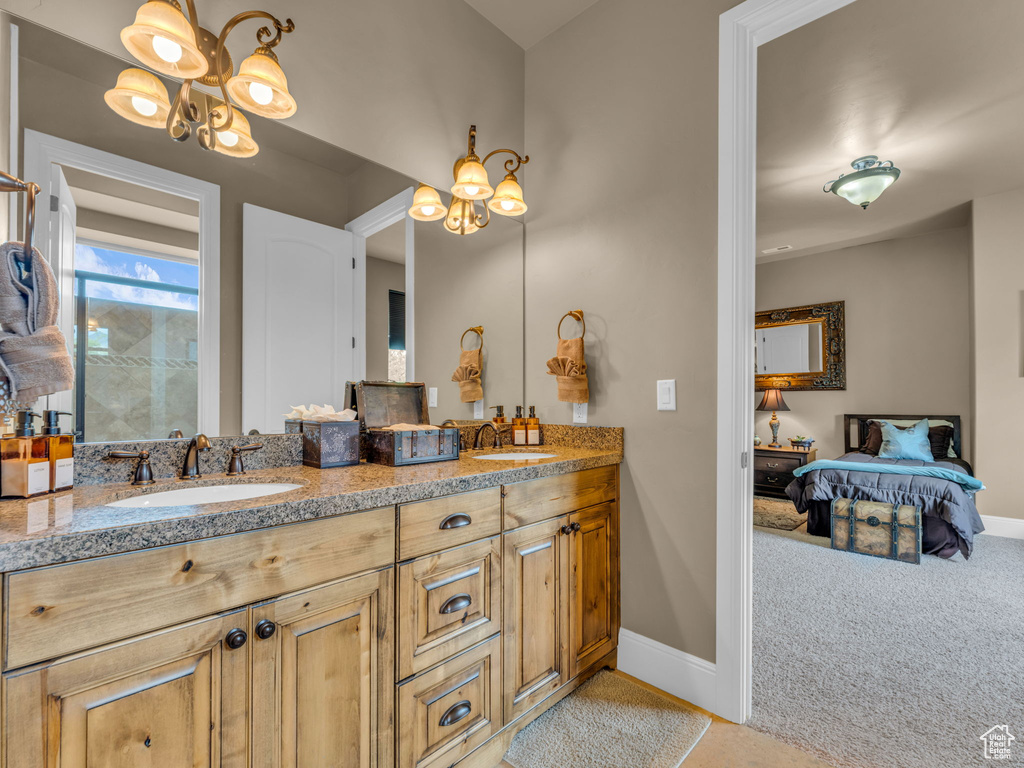 Bathroom with baseboards, double vanity, and ensuite bathroom