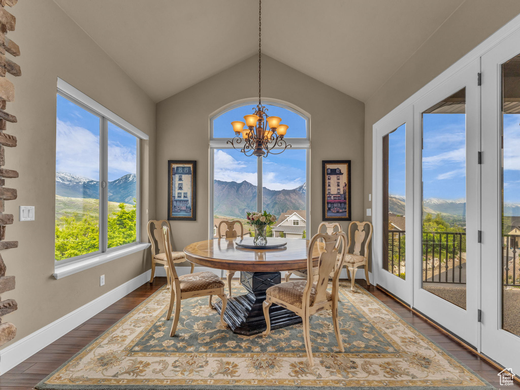 Dining area featuring a chandelier, a mountain view, vaulted ceiling, and baseboards